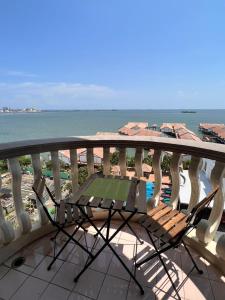 a table and chair on a balcony overlooking the ocean at Glory beach private PD in Port Dickson