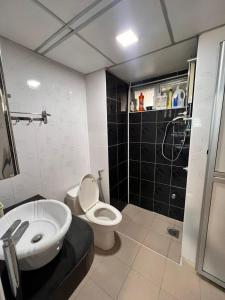 uma casa de banho com um WC branco e um lavatório. em Glory beach private PD em Porto Dickson