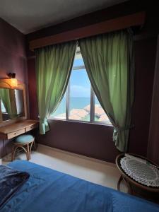 a bedroom with a bed and a large window at Glory beach private PD in Port Dickson