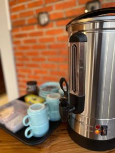 a coffee maker and cups on a tray on a table at Puu Pau Hotel & Coffee Shop in Labuan Bajo