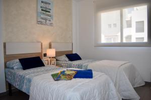 a hotel room with two beds and a window at Casa La Zenia in Playas de Orihuela +26 photos