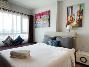 a bedroom with a large white bed and windows at 芭提雅Fnb Central 无边泳池 in Pattaya