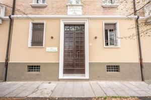 a house with a brown door on the side of it at Cucchiari Suite 8A in Modena
