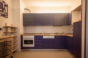 una cocina con armarios de color azul oscuro y fregadero en Residence I Gemelli, en Génova