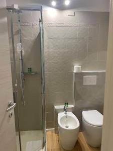 a bathroom with a shower and a toilet and a sink at Cucchiari Suite 8A in Modena