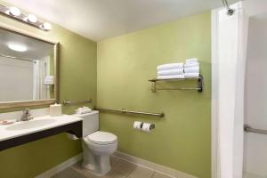 y baño con lavabo, aseo y espejo. en Days Inn by Wyndham Baltimore Inner Harbor, en Baltimore