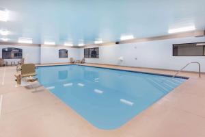 duży basen z niebieską wodą w budynku w obiekcie Super 8 by Wyndham Marysville/Port Huron Area w mieście Marysville
