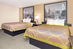 a hotel room with two beds and a picture of a city at Super 8 by Wyndham Mount Laurel in Mount Laurel