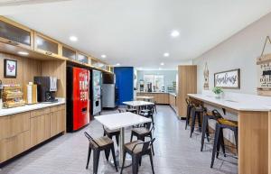 a restaurant with tables and chairs and a refrigerator at Microtel Inn & Suites Columbus North in Columbus