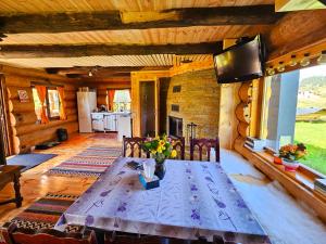 ein Esszimmer mit Tisch und Kamin in der Unterkunft La Căsuță in Vatra Dornei