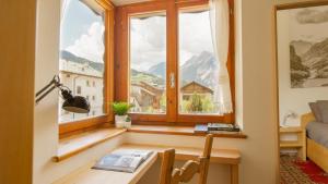 a room with a desk and a window with a view at Casa Agnese e Rino in Bormio