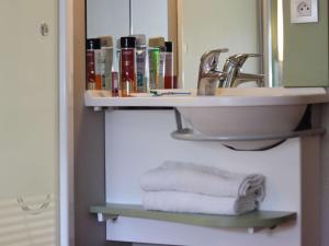 a bathroom with a sink and towels on a shelf at ibis Budget Paris La Villette 19ème in Paris