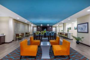 a lobby with a table and chairs and a bar at La Quinta by Wyndham Artesia in Artesia