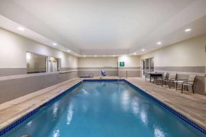 a swimming pool with a table and chairs at La Quinta by Wyndham Artesia in Artesia