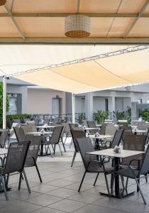 eine leere Terrasse in einem Restaurant mit Tischen und Stühlen in der Unterkunft Sunrise Village Hotel - All Inclusive in Platanias