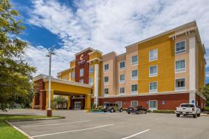 un hôtel avec des voitures garées dans un parking dans l'établissement Comfort Suites Denham Springs, à Denham Springs