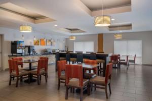 Comfort Suites Denham Springs في دينهام سبرينغز: مطعم بطاولات وكراسي وكاونتر