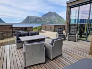 a patio with a table and chairs on a wooden deck at Classy Cabin Lofoten in Kleppstad