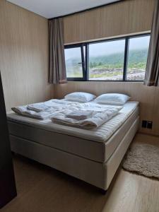 een bed in een kamer met een groot raam bij Classy Cabin Lofoten in Kleppstad