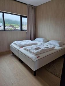 a bedroom with two beds and a large window at Classy Cabin Lofoten in Kleppstad