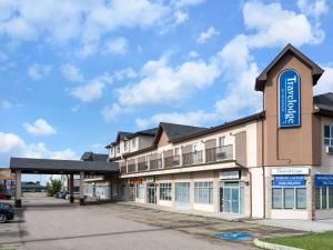 un edificio con una señal azul en el costado. en Travelodge by Wyndham Wetaskiwin, en Wetaskiwin