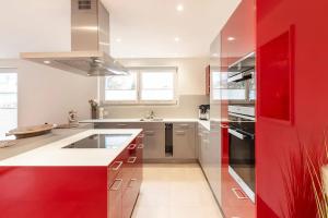 a kitchen with red cabinets and a red wall at Luxus 3,5 Zi-Whg 128m2, 8 Min zum See & Altstadt in Stein am Rhein