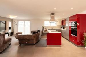 a living room with a couch and a red kitchen at Luxus 3,5 Zi-Whg 128m2, 8 Min zum See & Altstadt in Stein am Rhein