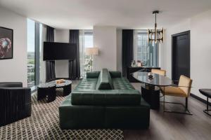 a living room with a green couch and a table at Thompson Austin, by Hyatt in Austin