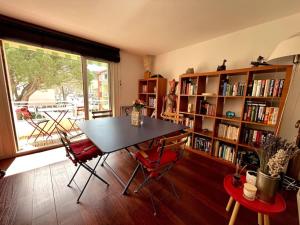 a room with a table and chairs and a book shelf at Les Cigales in Le Pradet
