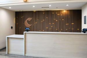 a reception desk with a c sign on a wall at Comfort Inn & Suites NW Milwaukee in Germantown