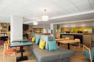 een lobby met tafels en stoelen en een cafetaria bij Home2 Suites By Hilton Quebec City in Québec