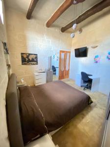 a bedroom with a large bed and a desk at Vintage Farmhouse in Qormi