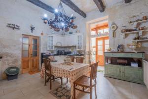 a kitchen with a table and chairs and a chandelier at Vintage Farmhouse in Qormi