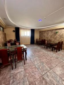 a dining room with wooden tables and chairs at InJoy hostel in Shymkent