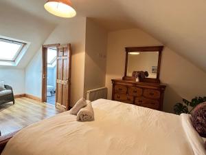 a bedroom with a bed and a dresser and a mirror at The Lodge, Monkstown in Monkstown