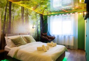 a bedroom with a forest mural on the wall at Relaxveld Nature in Curtea de Argeş