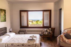 1 dormitorio con cama, ventana y sofá en Affittacamere Cigui, en Muggia