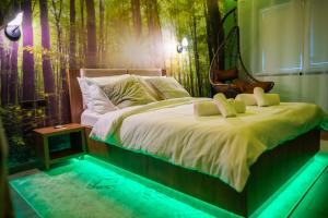 Un dormitorio con una cama grande con una pared de bosque. en Relaxveld Nature, en Curtea de Argeş