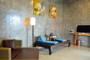 uma sala de estar com um sofá e uma mesa em Arun Rawee อรุณ รวี em Chiang Mai
