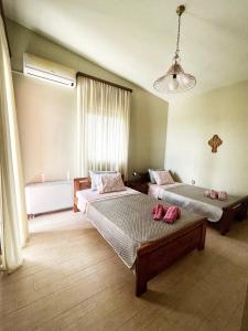 a bedroom with two beds with pink shoes on them at HomeKatrin in Aigio