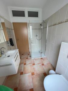 a bathroom with a shower and a toilet and a sink at Varus Apartments in Detmold