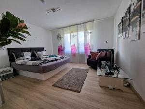 a bedroom with a bed and a couch at Ferienwohnung Starennest mit direktem Harzblick in Bad Lauterberg
