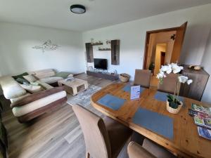 a living room with a wooden table and a couch at Ferienwohnung Starennest mit direktem Harzblick in Bad Lauterberg +13 photos