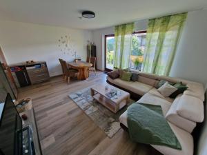 a living room with a couch and a table at Ferienwohnung Starennest mit direktem Harzblick in Bad Lauterberg