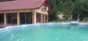a swimming pool in front of a house at Casa LUCA in Luncasprie