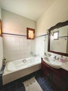 a bathroom with a tub and a sink and a mirror at HomeKatrin in Aigio