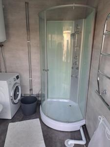 a shower in a bathroom with a washing machine at Harmony in Farhult in Farhult