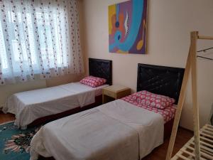 a bedroom with two beds and a painting on the wall at hilal in Erzurum