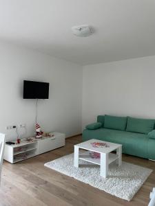 クープレスにあるApartment Unaの緑のソファとテーブルのあるリビングルーム