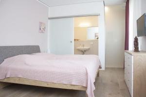 Schlafzimmer mit einem Bett, einem Waschbecken und einem Spiegel in der Unterkunft FreiRaum in Vöhringen